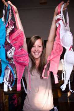 woman holding several bras